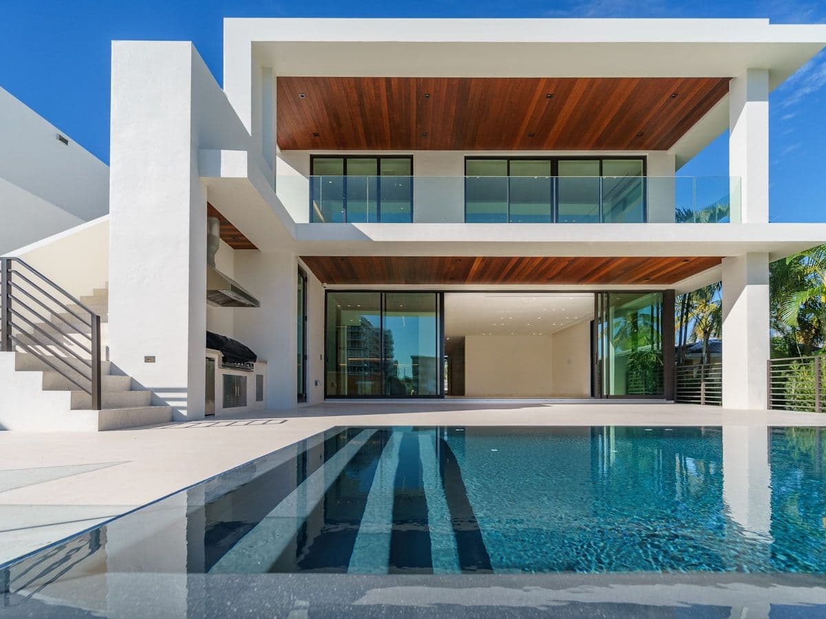 Same luxury home at twilight with warm interior glow and dramatic blue sky
