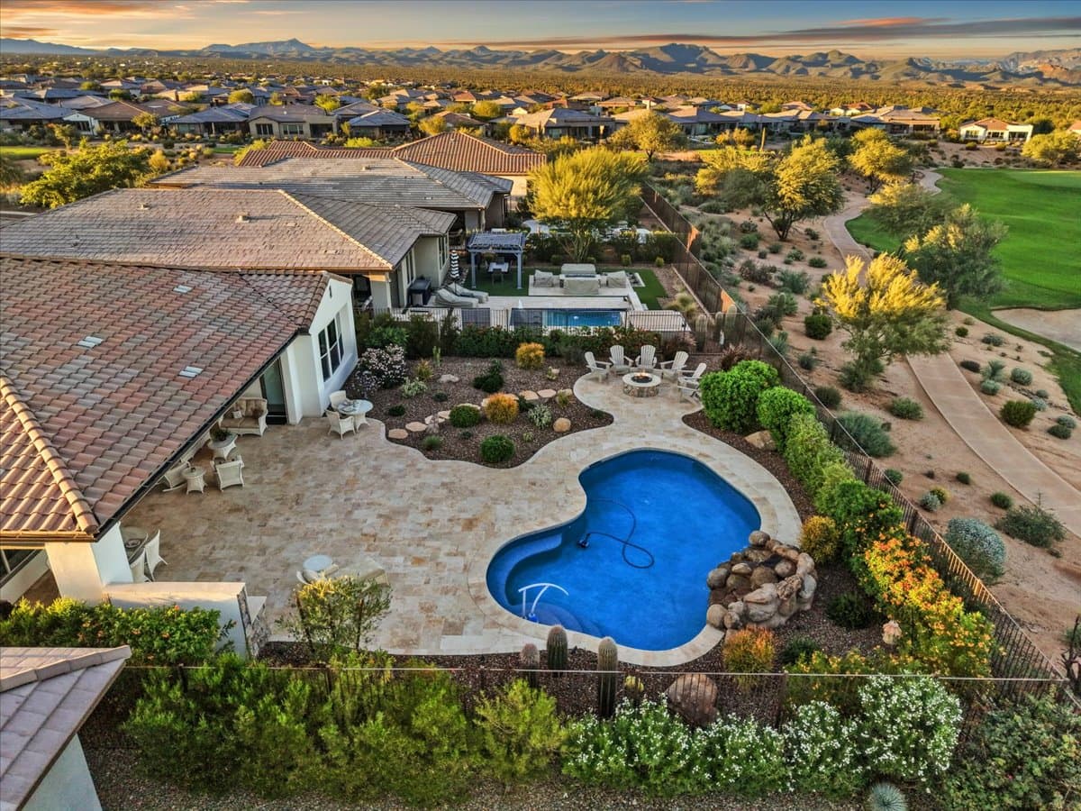 Aerial view of a desert backyard pool at sunset with all lights off